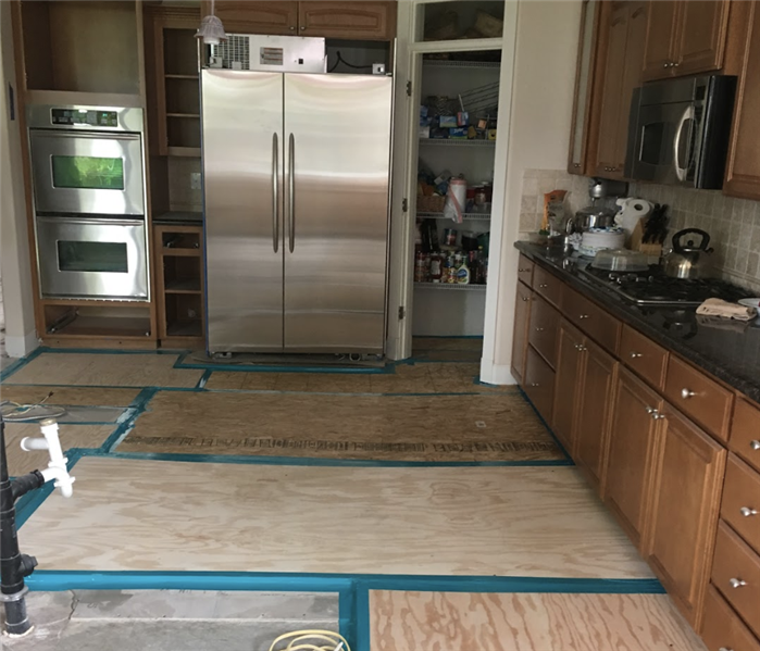 a kitchen during demolition with flooring removed